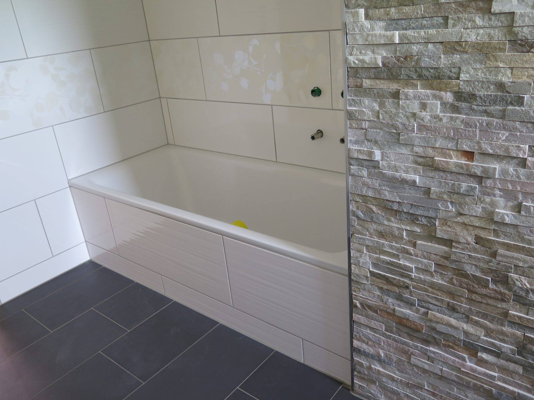 Neue Badewanne vor Natursteinwand