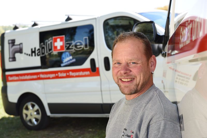 Martin Hablützel vor dem Firmenbus mit Logo
